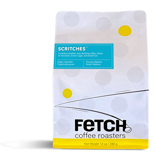 Scritches has a turquoise label offset to the left and toward the top of the white reclosable coffee bag. The bottom of the bag has a yellow band, and the logo shows a bean sitting at the base of the 'h' in the word Fetch.